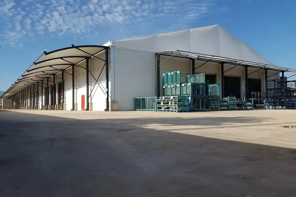 Sanayi sahasında kurulmuş büyük beyaz depo çadırı