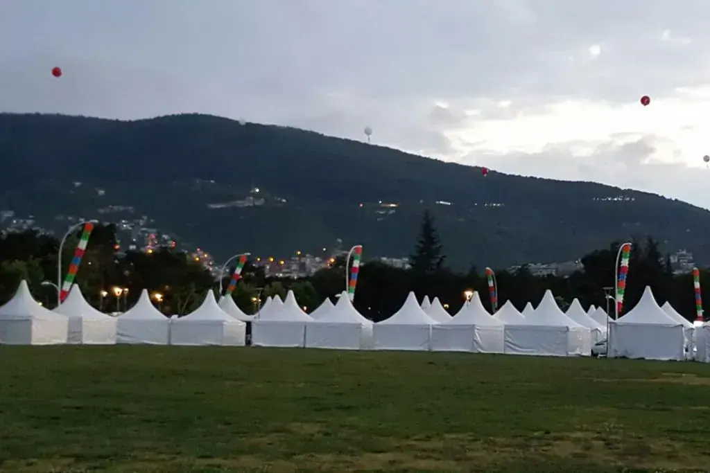 Akşamüstü dağ eteğindeki çim alanda sıralanmış pagoda çadırları
