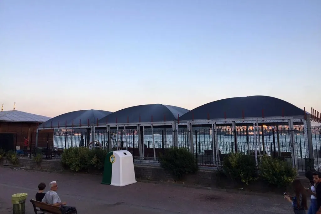Akşam saatlerinde camlı, kemer çatılı iskele bekleme yapısı