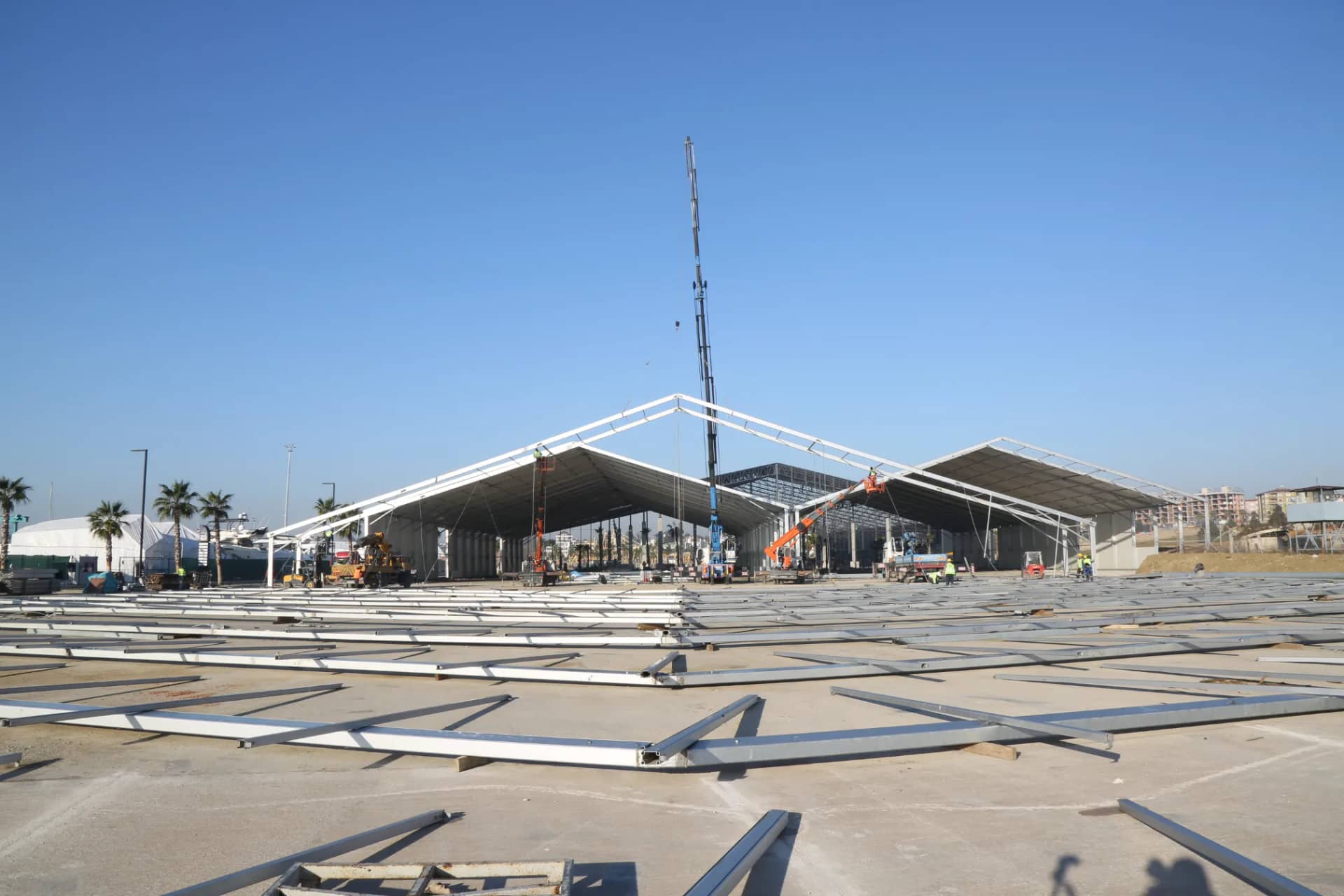 Vinçle makas kaldırılan depo çadırı kurulumu, zeminde serili taşıyıcı profiller