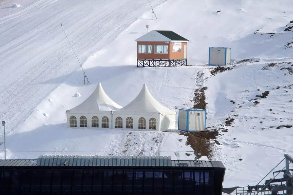 Karla kaplı kayak pistinde kurulmuş iki pagoda çadırı, havadan görünüm