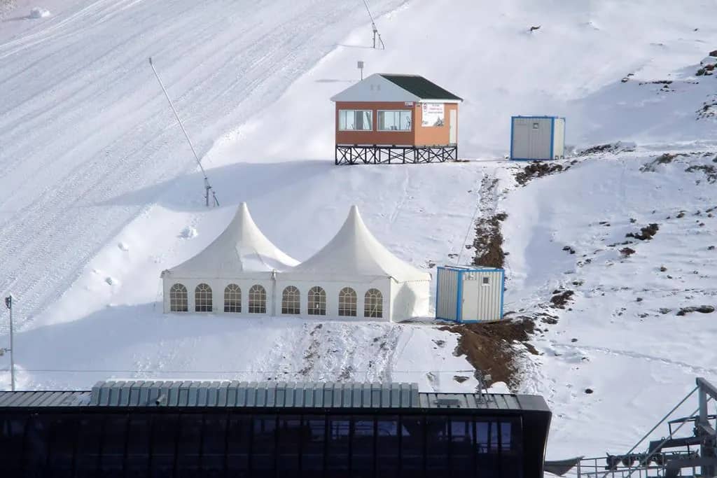 Karla kaplı kayak pistinde kurulmuş iki pagoda çadırı, havadan görünüm