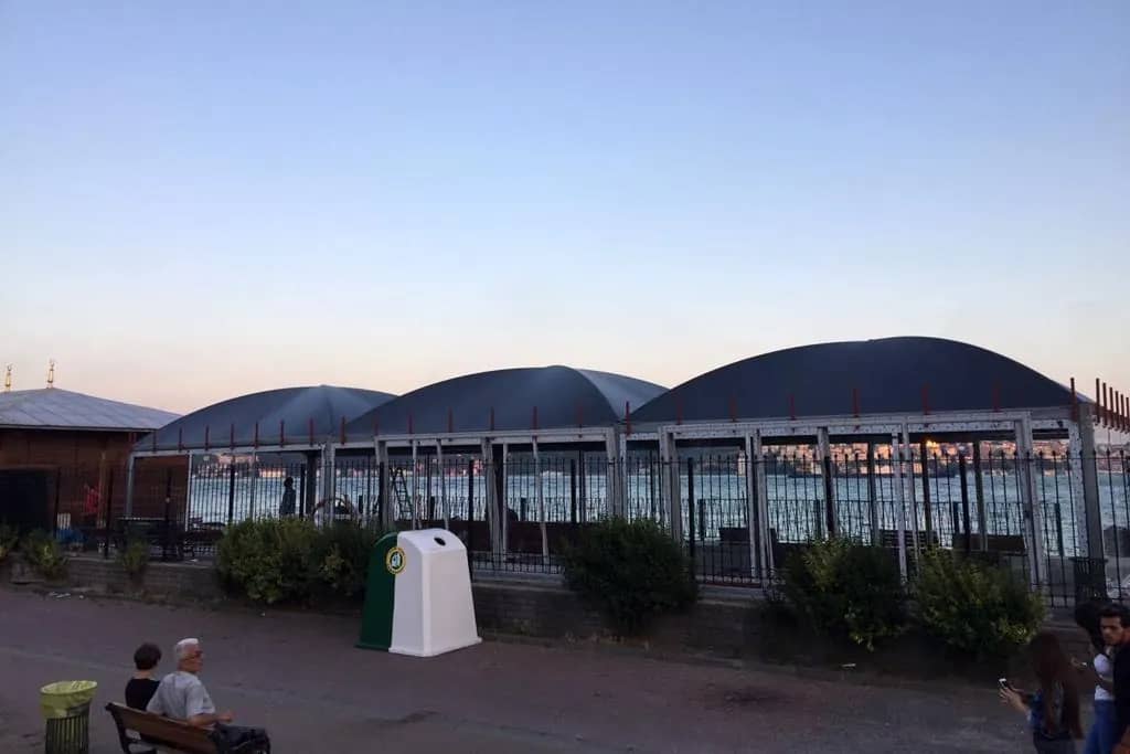 Akşam saatlerinde camlı, kemer çatılı iskele bekleme yapısı