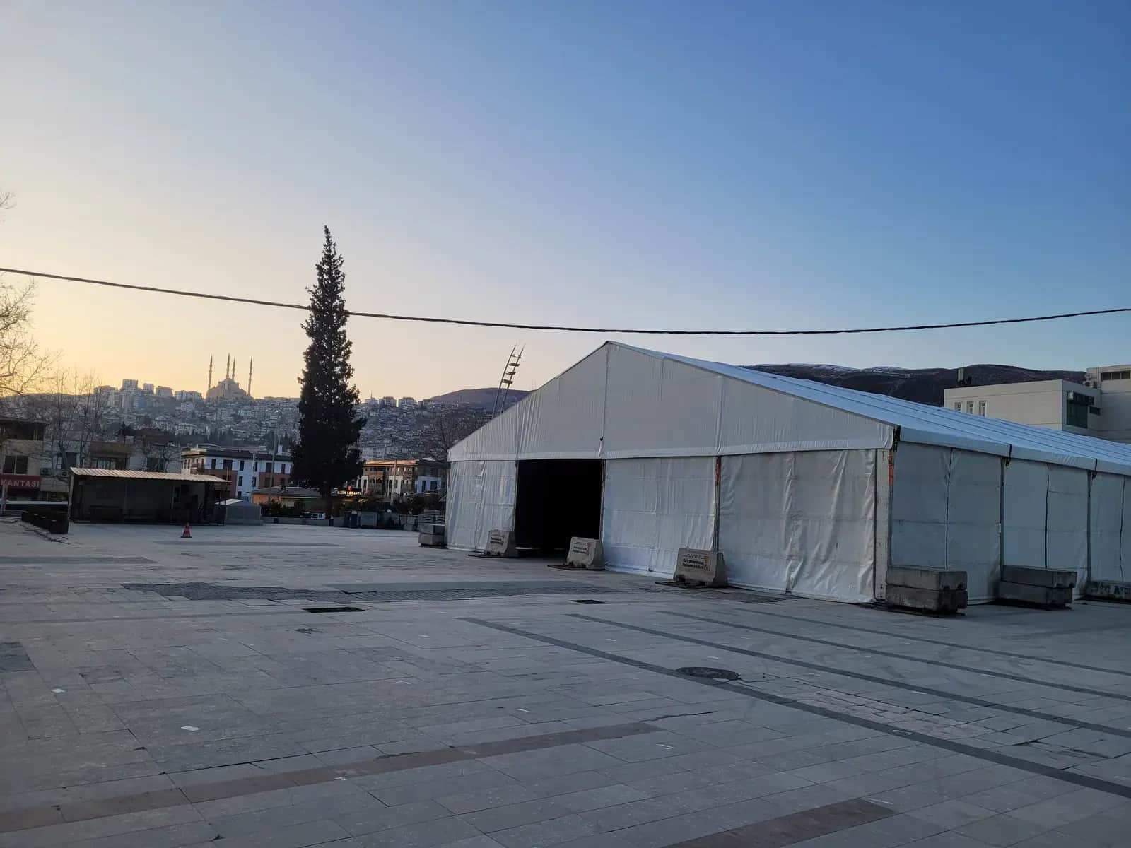 Gün batımında meydanda kurulmuş beyaz ramazan çadırı