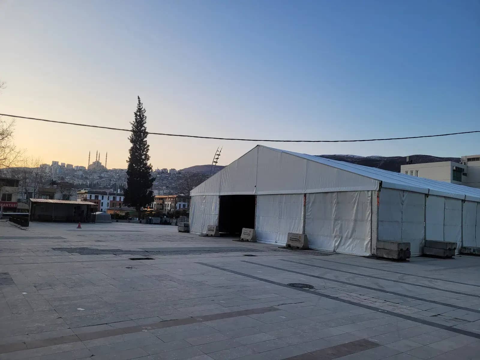 Gün batımında meydanda kurulmuş beyaz ramazan çadırı