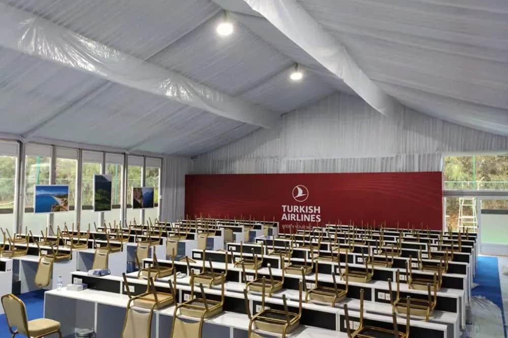 Turnuva çadırında sıralı sandalyelerle kurulmuş konferans düzeni