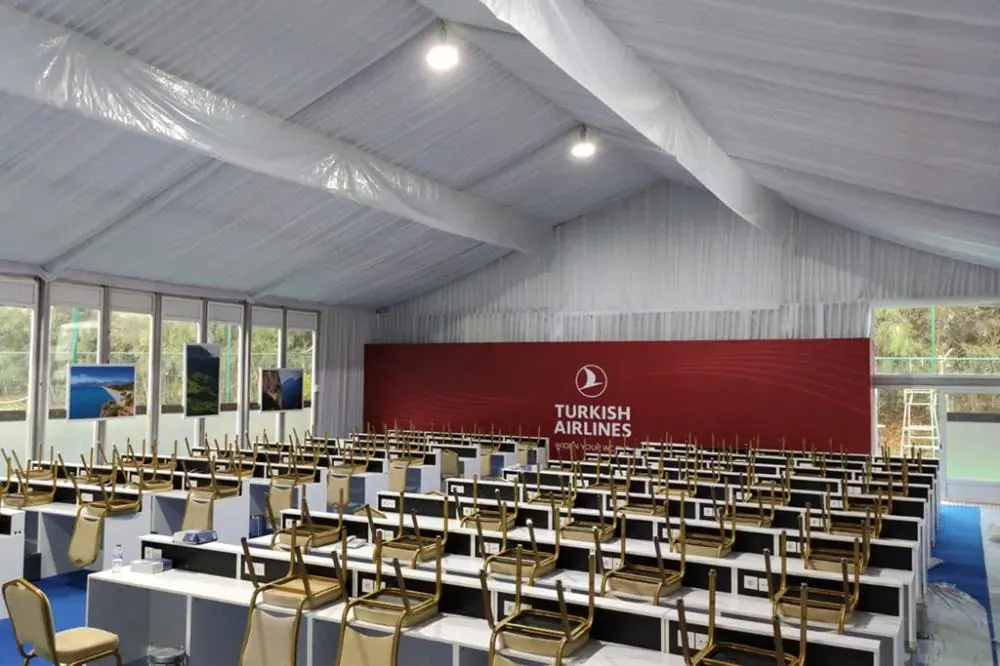 Turnuva çadırında sıralı sandalyelerle kurulmuş konferans düzeni
